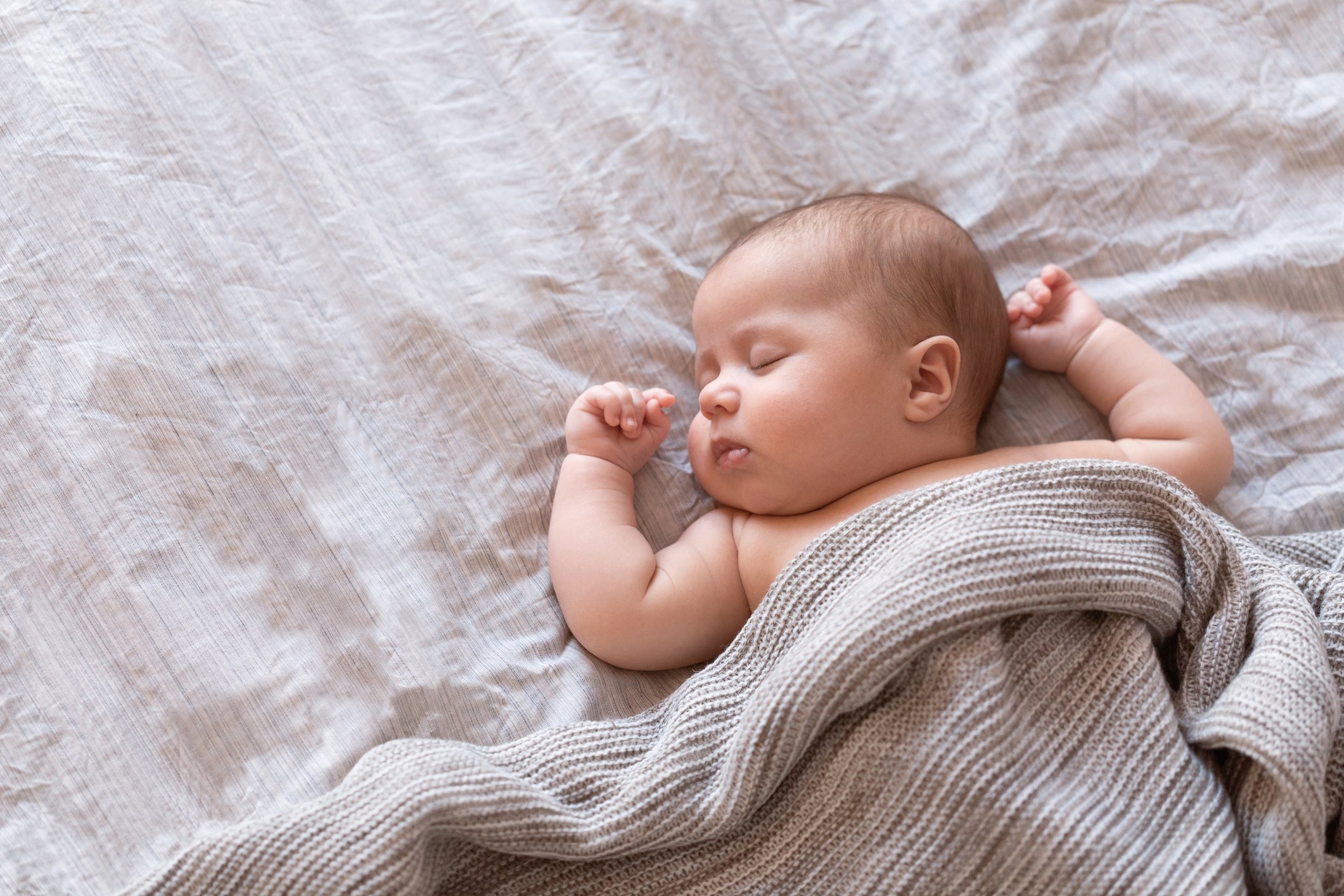 Peaceful baby lying on a bed and sleeping at home Peaceful baby lying on a bed and sleeping at home